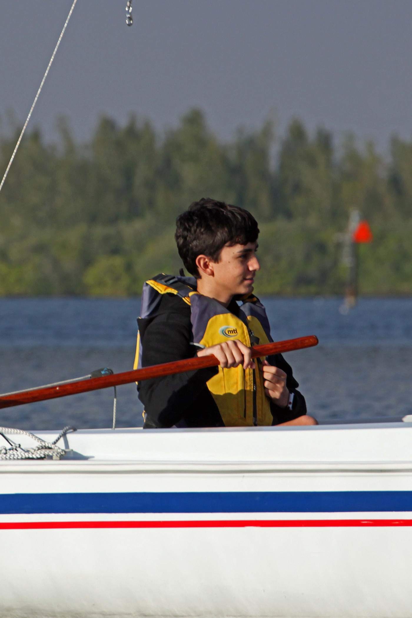 One young man looking to the side, sailing